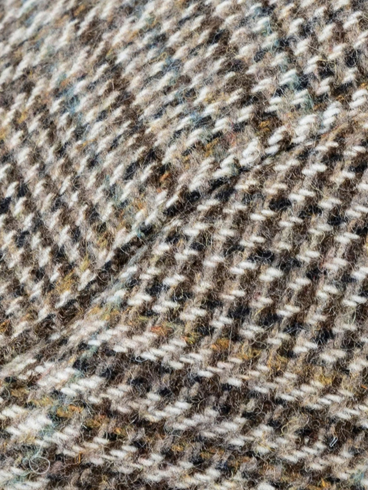 Close-up of the brown and cream glen plaid check wool blend tweed fabric on the Dents flat cap