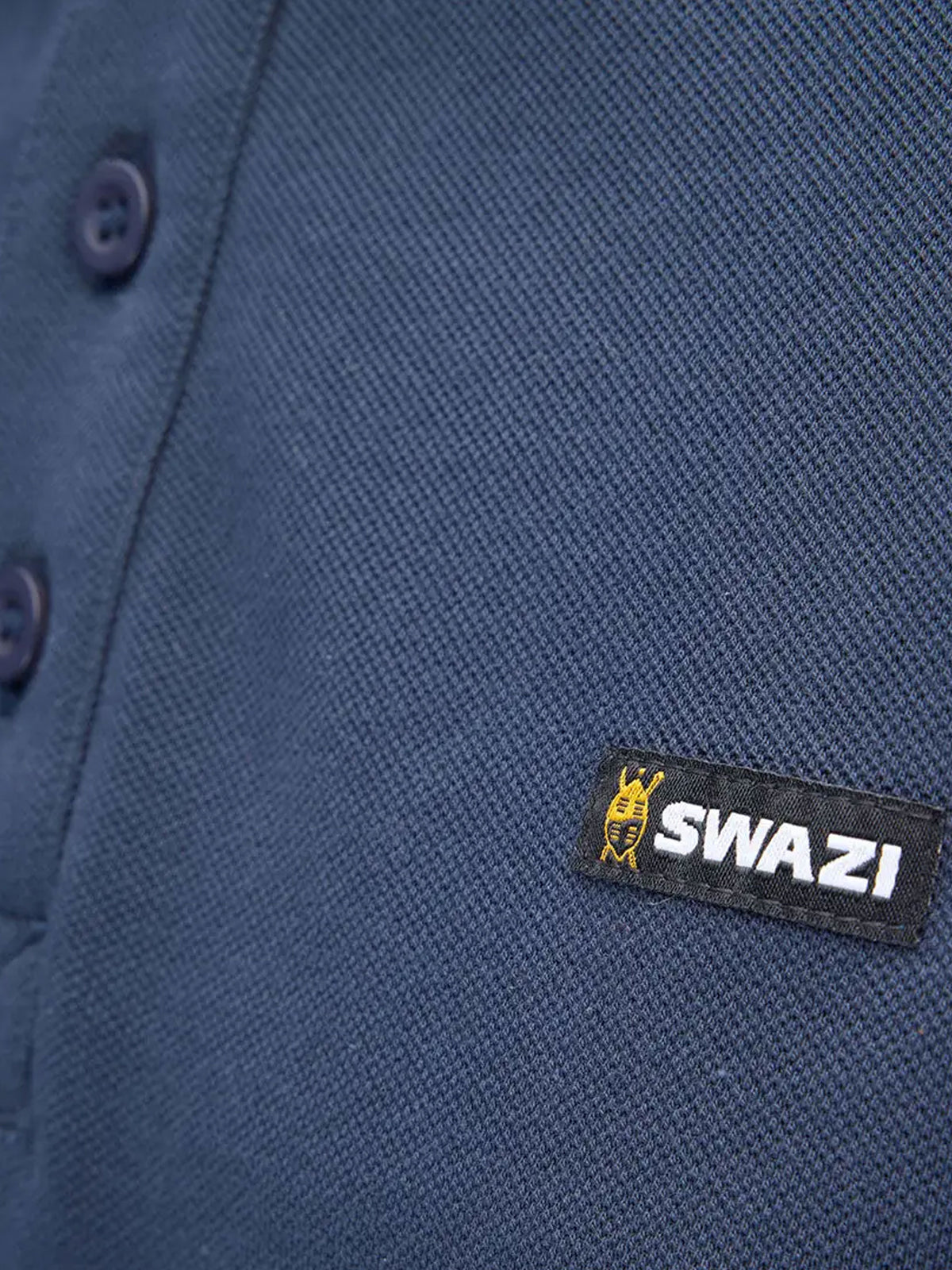 Close-up of Swazi logo tab on navy cotton piqué polo shirt