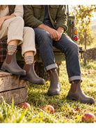 Blundstone 550 walnut brown leather Chelsea boots worn on an orchard bench