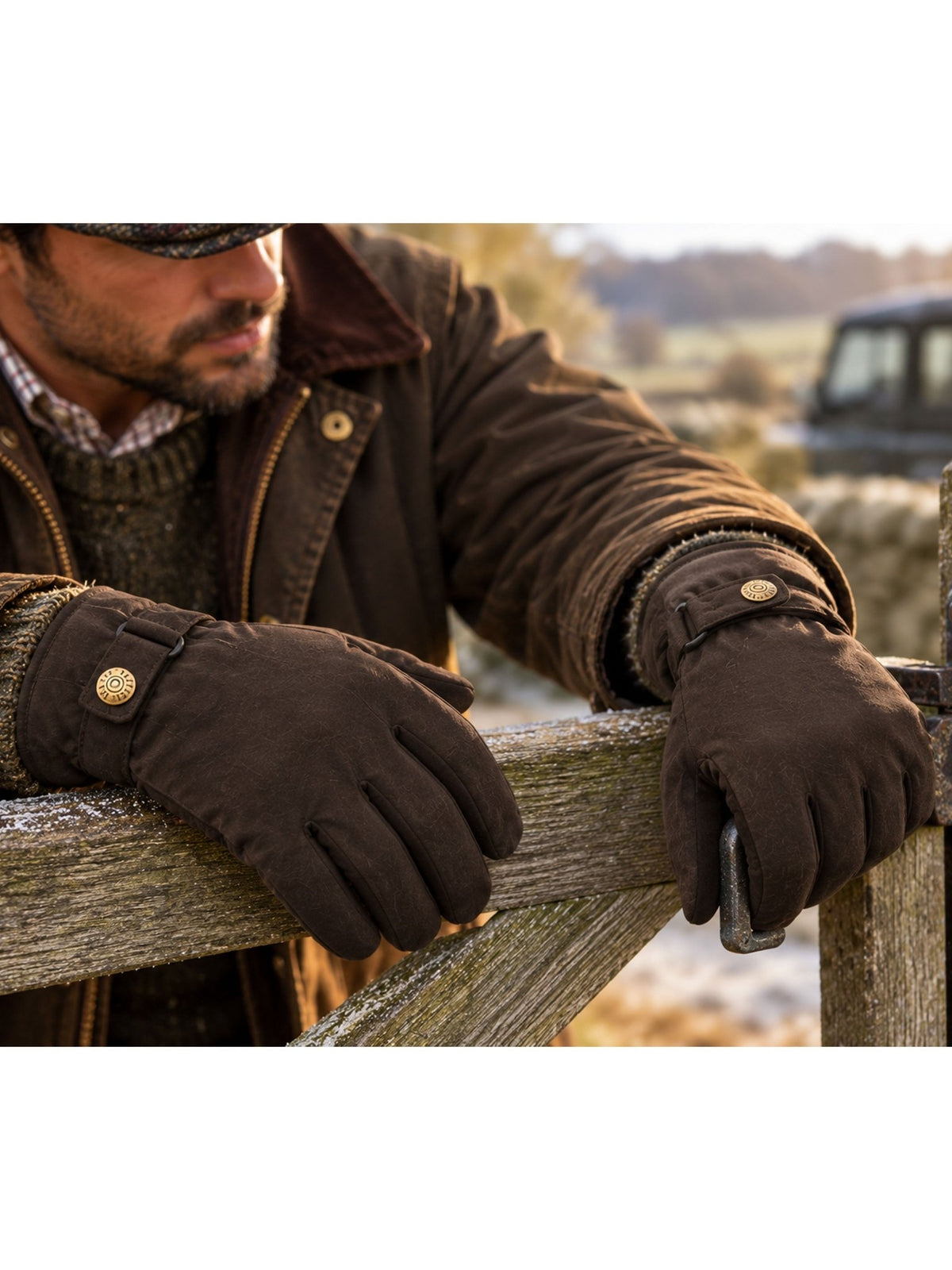 Dents men's water resistant waxed cotton gloves, worn with waxed jacket leaning on a gate