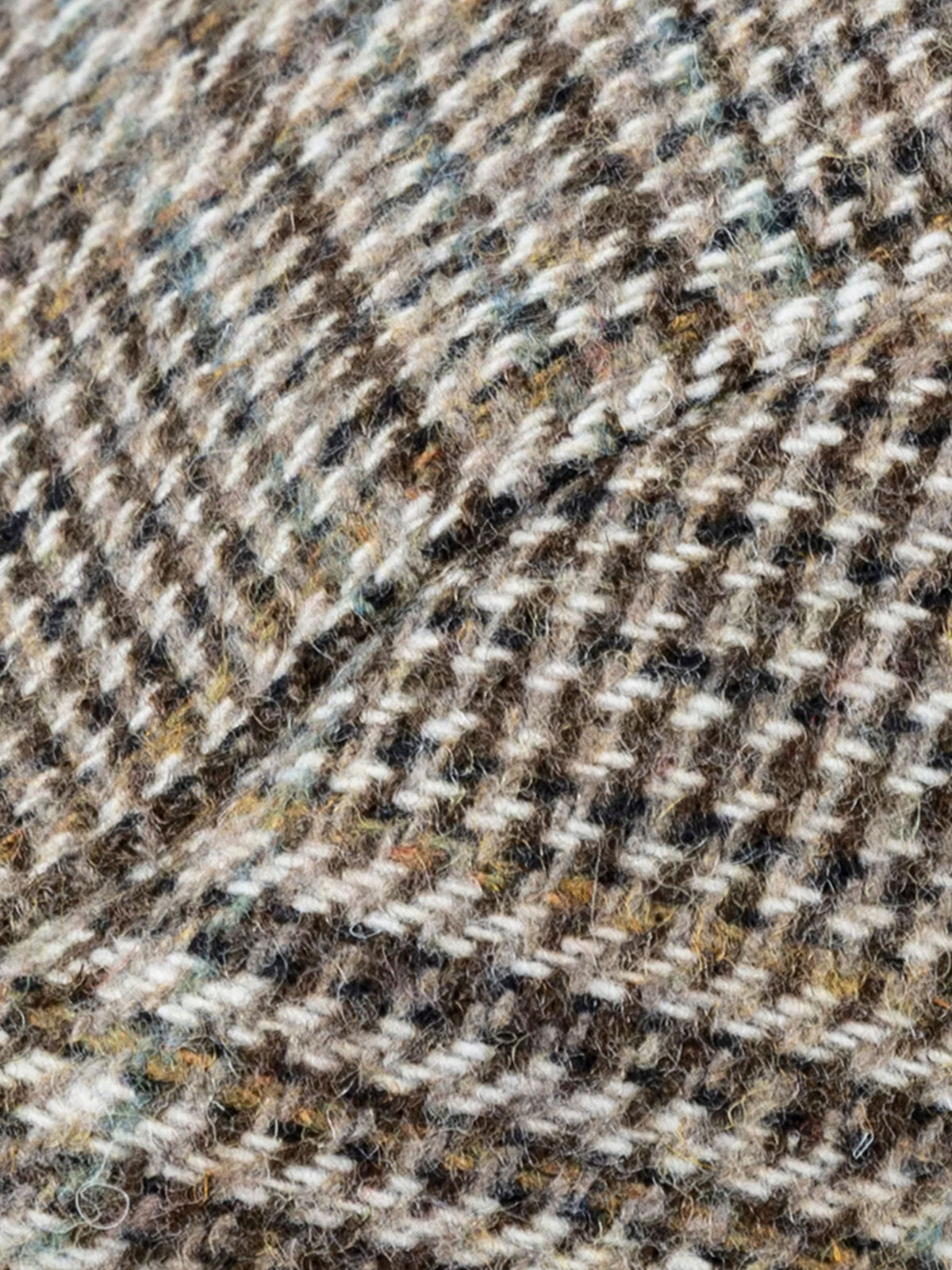 Close-up of the brown and cream glen plaid check wool blend tweed fabric on the Dents flat cap