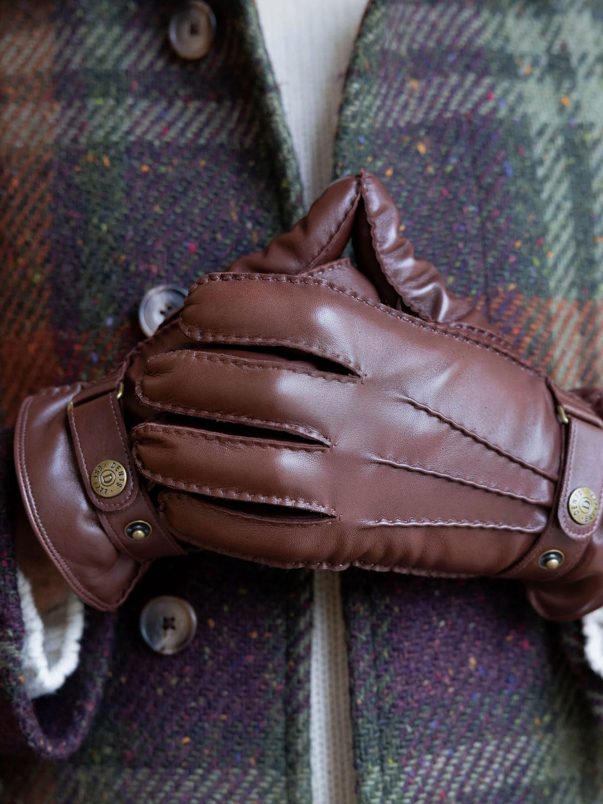 Dents Tetbury men's brown leather gloves, close-up worn with a plaid coat