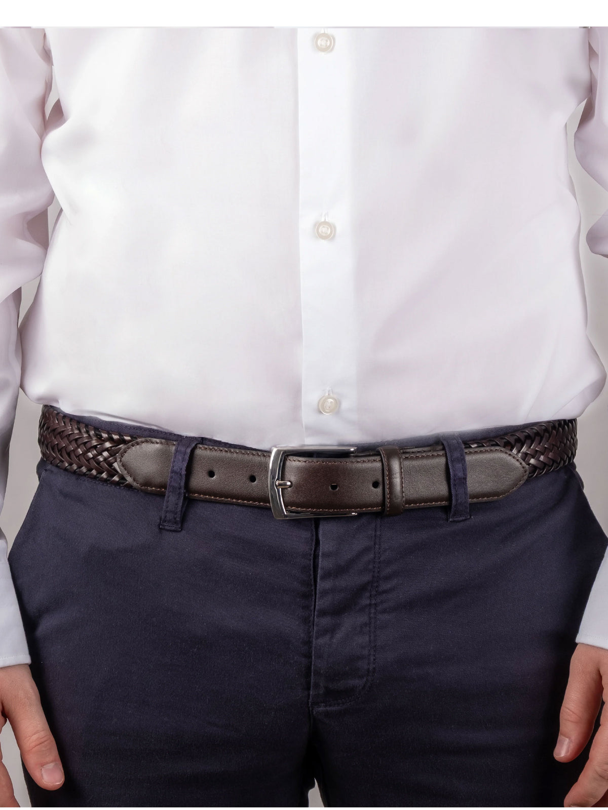 Dents men's brown plaited leather belt worn with white shirt and navy trousers