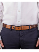 Dents men's tan plaited leather belt worn with white shirt and navy trousers