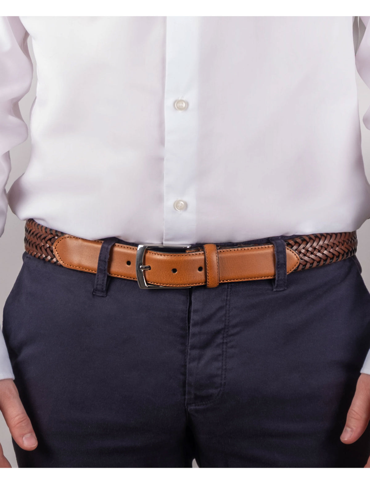 Dents men's tan plaited leather belt worn with white shirt and navy trousers