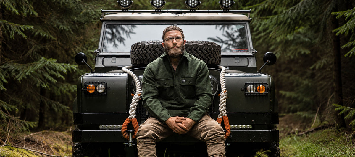 a man sitting on a 4x4 in the coutryside wearing Swandri clothing 