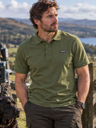 Man wearing Swazi men's olive green cotton piqué polo shirt outdoors