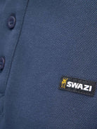 Close-up of Swazi logo tab on navy cotton piqué polo shirt