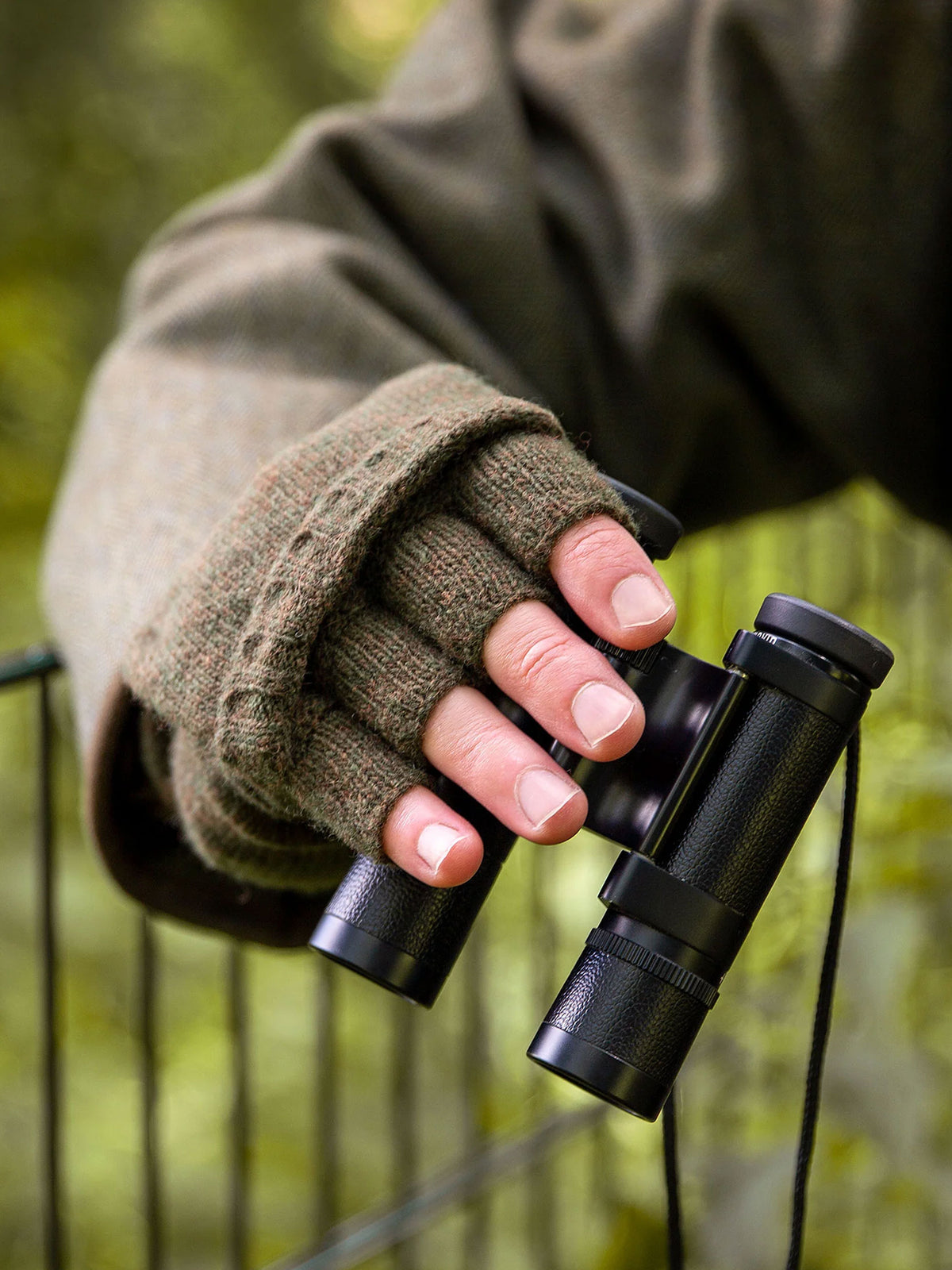 Dents men's knitted shooting gloves with fingerless grip, worn while holding binoculars