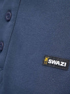 Close-up of Swazi logo tab on navy cotton piqué polo shirt